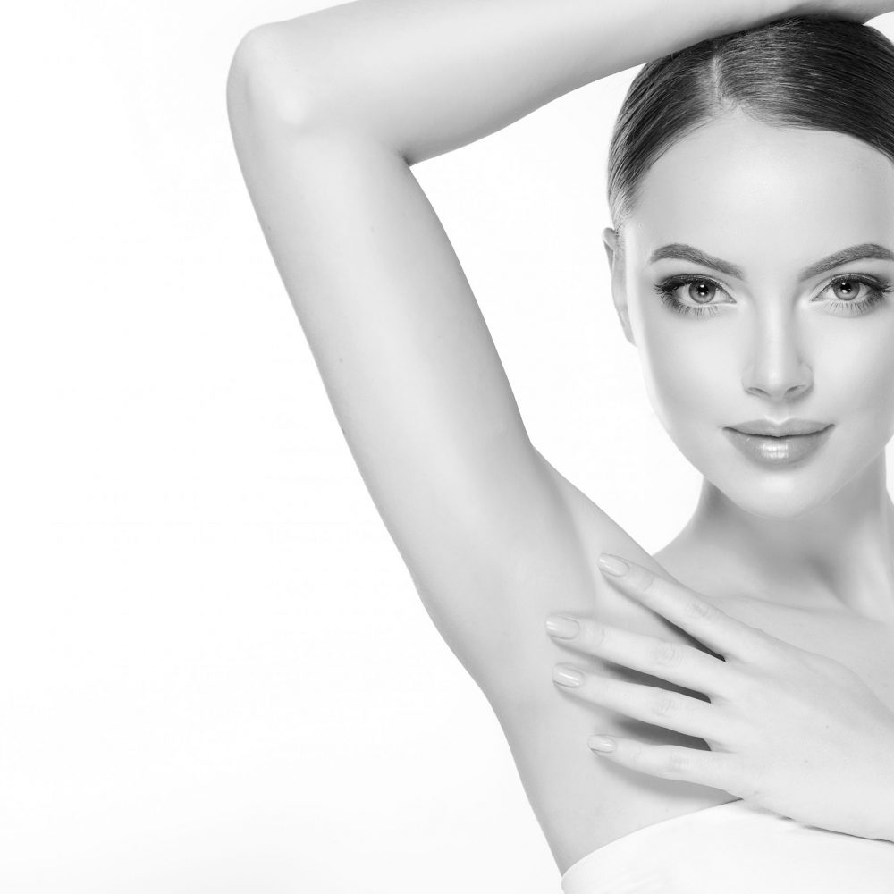 Armpit epilation, lacer hair removal. Young woman holding her arms up and showing clean underarms, depilation  smooth clear skin .Beauty portrait.